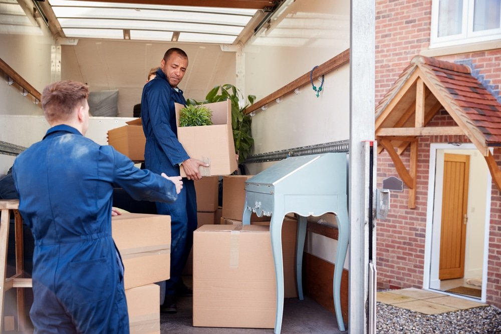 Removal,Company,Workers,Unloading,Furniture,And,Boxes,From,Truck,Into