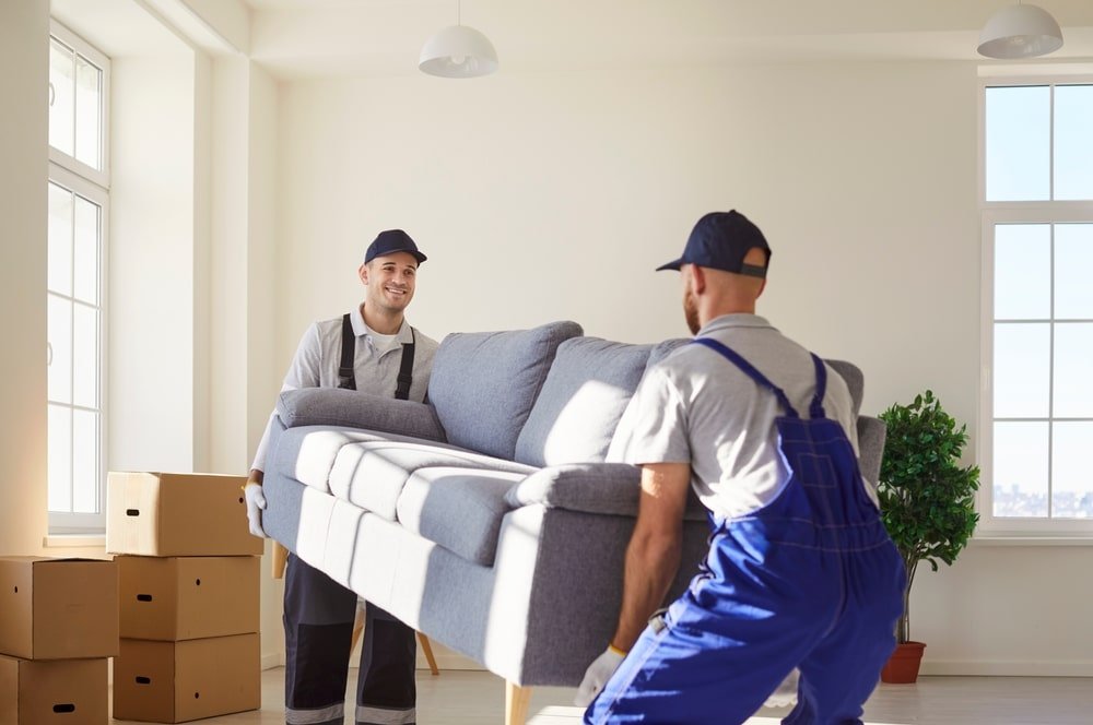 Twee verhuizers tillen een bank tijdens verhuizing in Den Haag